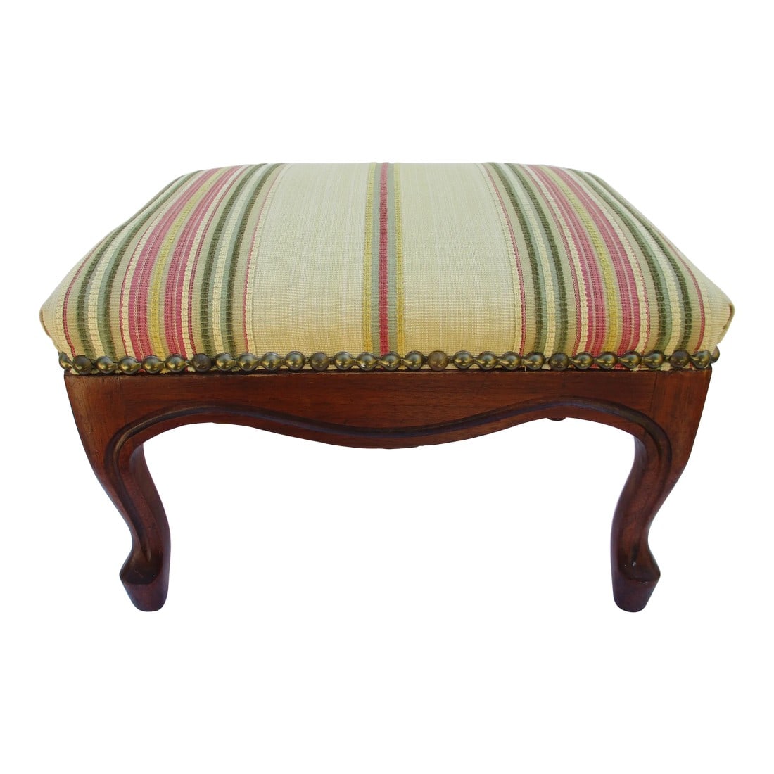 Cream and Striped French Country Style Footstool: A beautiful upholstered French style footstool with a carved apron and brass tacks for an accent. The cream colored upholstery is highlighted by green, pink, yellow and white stripes. This vintage