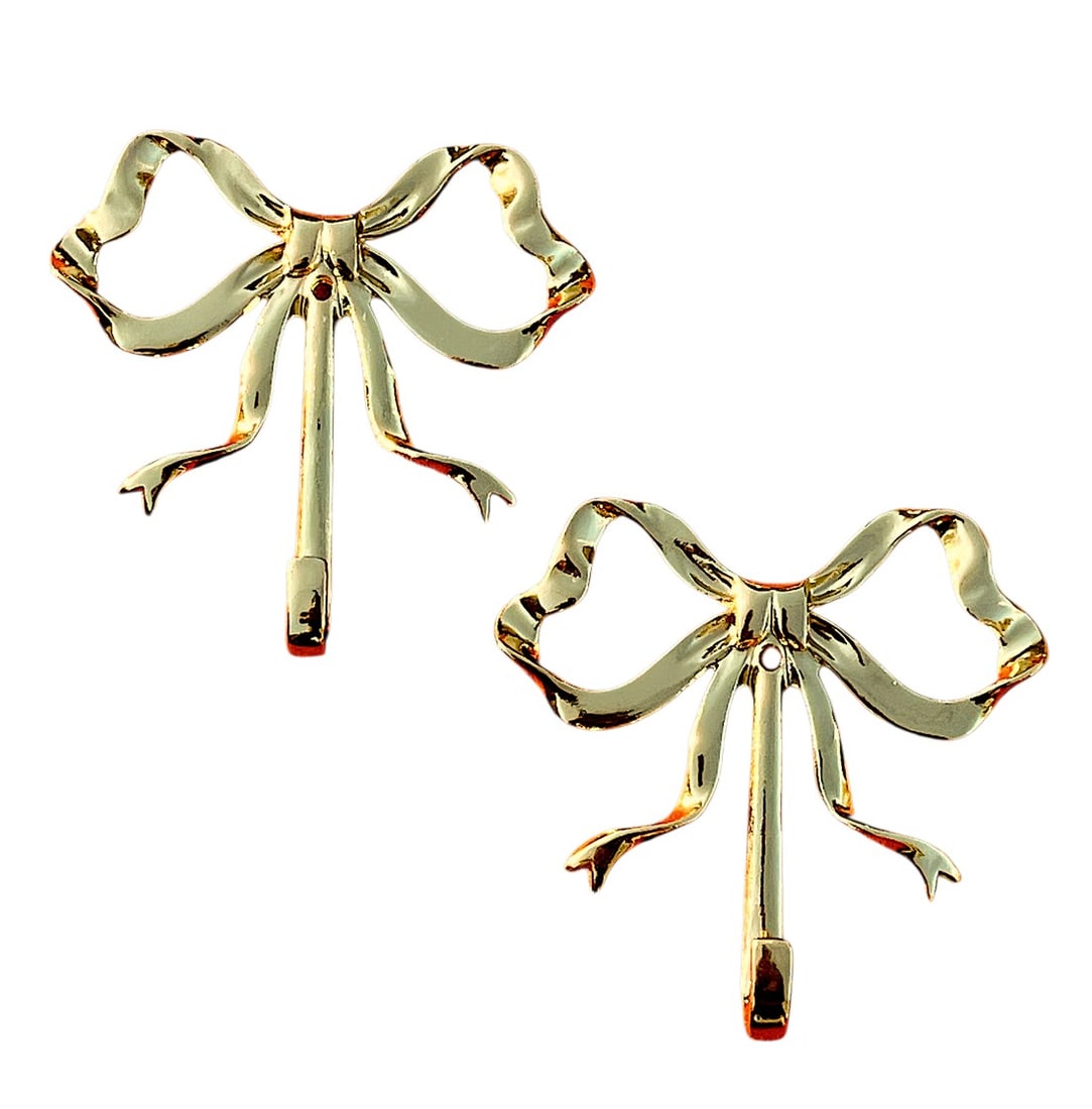 1990s Lacquered Brass Bow Wall Hooks - a Pair: Pair of brass bow wall hooks. Each bow is crafted to resemble a ribbon tied into a classic bow shape, with loops on both sides and flowing ribbon tails beneath. The finish is lacquered, insuring the