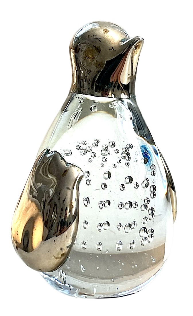 1960s Penguin Murano Style Bubble Glass and Silver Chrome Paperweight: 1960s Murano-style penguin paperweight adds a playful yet polished accent to any surface. Crafted from clear glass with suspended air bubbles and finished with a silver chrome head and flippers, this