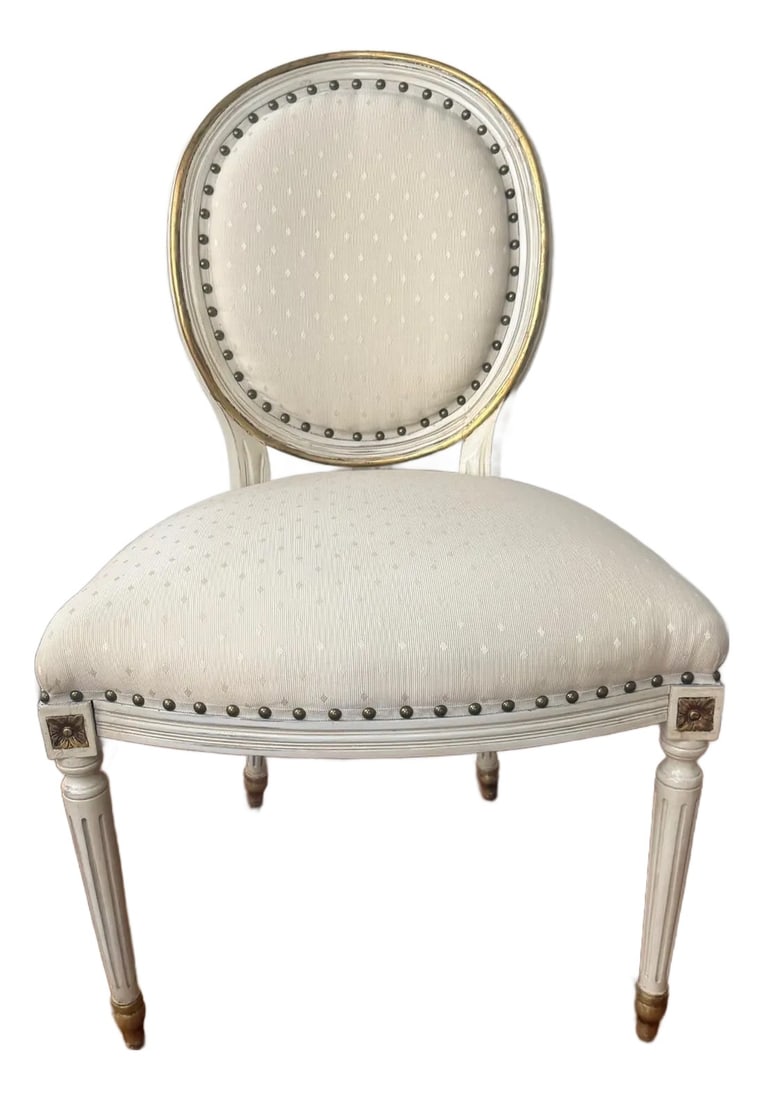 Vintage French Louis XVI Style Carved Wood Dining Chair With Original Painted Finish: This elegant mid-20th century dining chair, crafted in the French Louis XVI style, features exquisite hand-carved detailing and retains its original painted wood finish. The chair showcases the classi