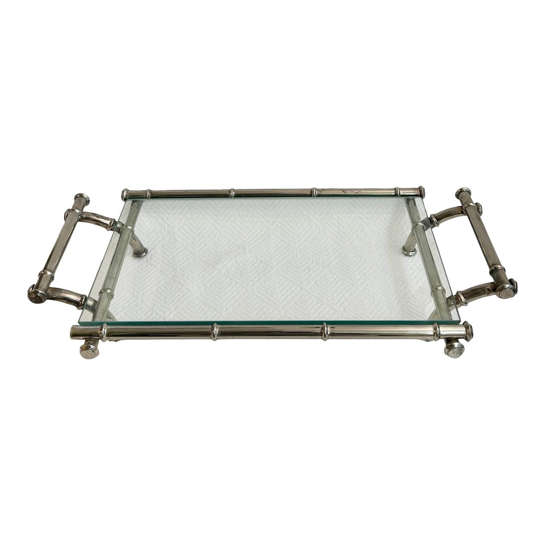 1960's Hollywood Regency Faux Bamboo Silver Plate Tray With Glass Top: Attributed to Duchin, this faux bamboo silver plate tray was a popular item in the 1960's. The glass surface sits on a stand with 4 legs and handles at each end. We love this tray as an addition to