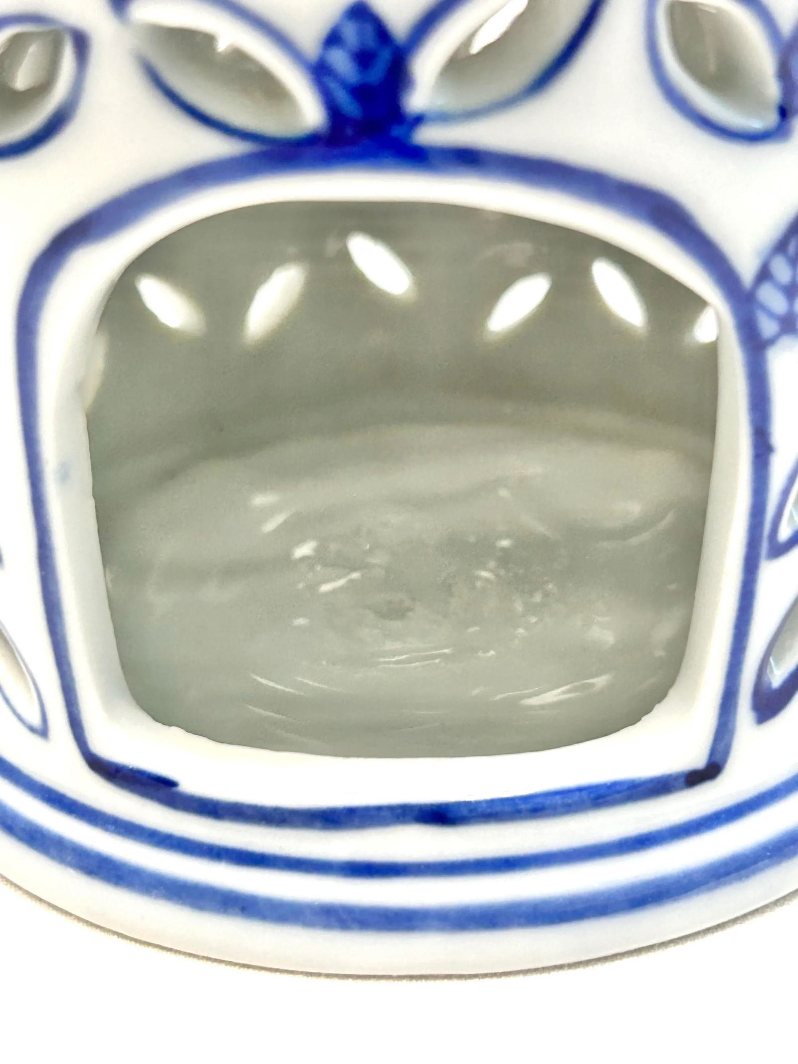 1980s Blue and White Chinoiserie Pagoda Candle Holder: A beautiful chinoiserie blue and white ceramic pagoda shaped ceramic candle holder. The top has a ceramic loop for hanging if desired. This can be used as a candle holder or just as a pretty