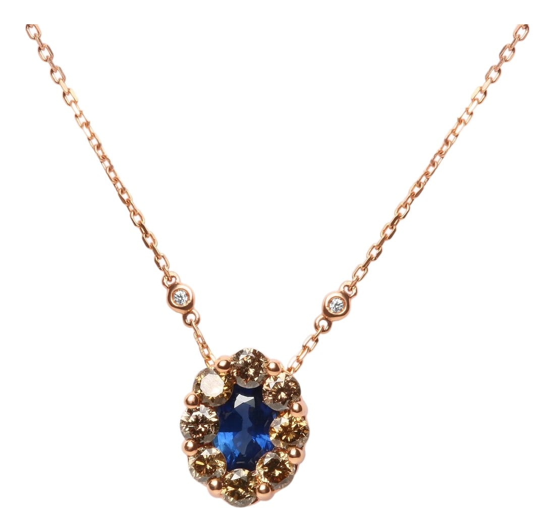 18K Rose Gold 5/8 Cttw White and Brown Diamond Accent and 7 x 4mm Oval Blue Sapphire Gemstone Statem: This 18k rose gold station necklace is a look you will turn to often thanks to its effortless and classy styling. At the center of this spectacular piece is nestled a 7 x 4mm oval heat-treated blue