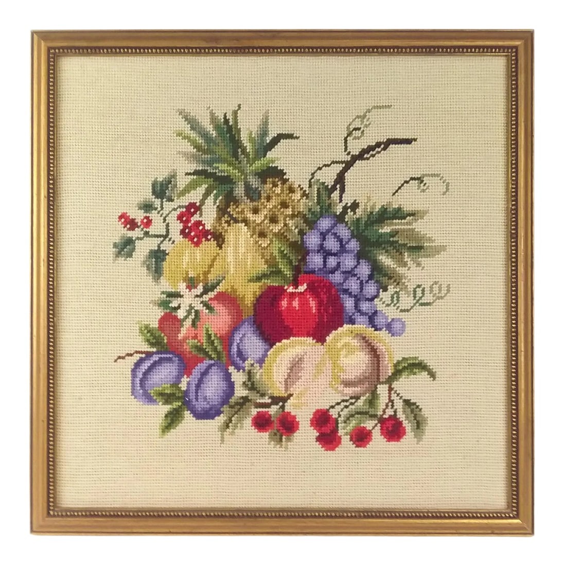 Vintage Hand Created Needlepoint Artwork: Colorful flowers and fruit make up this gorgeous needlepoint design. We have plums, apples, pineapple, grapes, and cherries. Framed in a wood Vintaged gold and stamped by the framer on the reverse. Cl