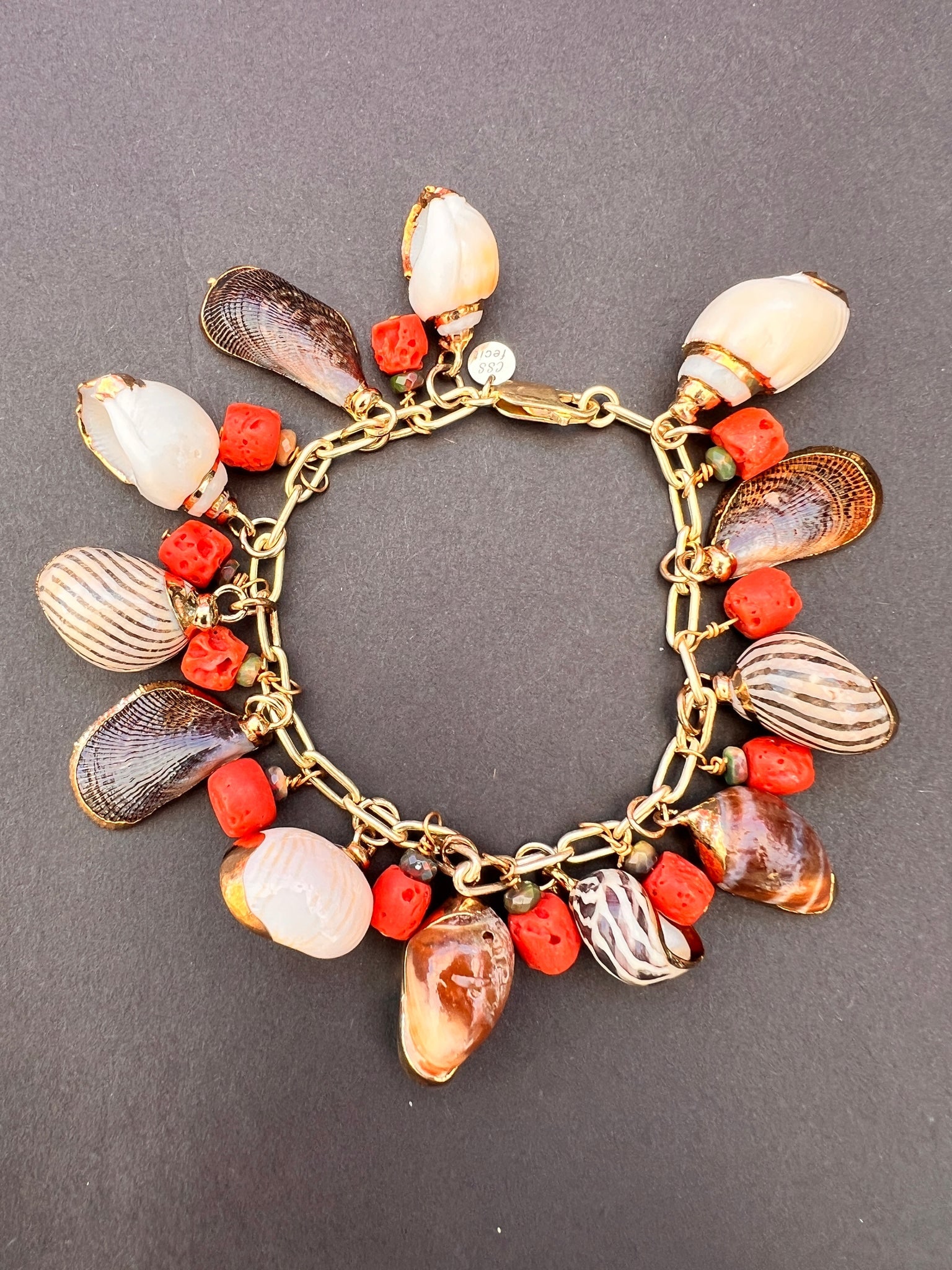 Seashell Charm Bracelet with Apple Coral: Title:Seashell Charm Bracelet with Apple Coral Description:Charming assorted gold-rimmed Seashell Charms with Apple Coral Beads on a Vermeil Link Charm Bracelet. Signed CSS - Vermeil - 7" long Reserve
