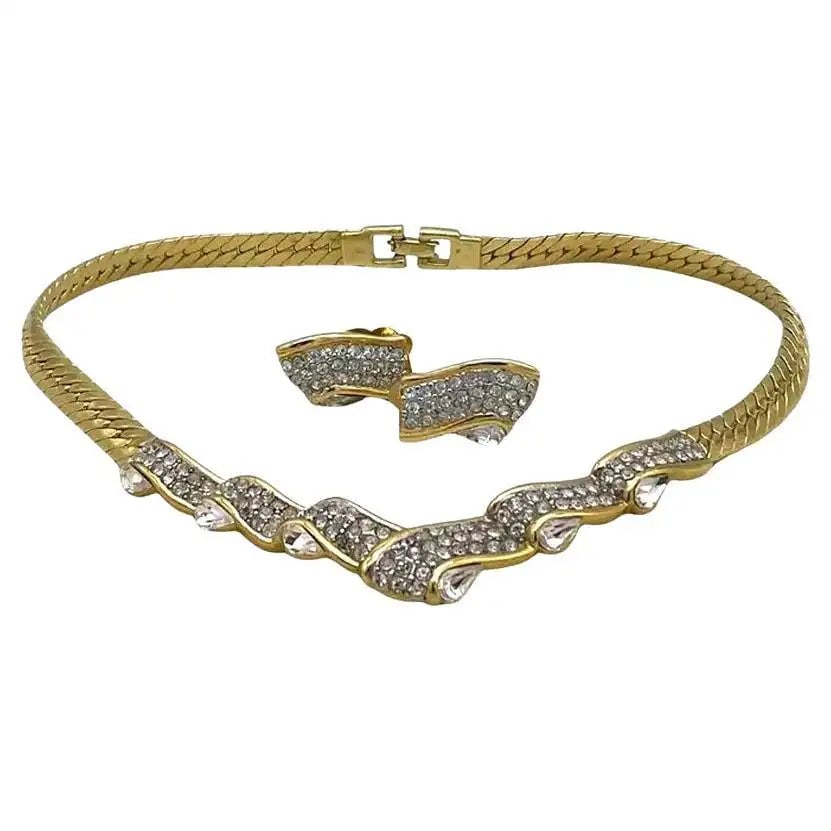 Givenchy Rhinestone on Gold-tone Necklace and Clip-on Earrings Set: This is a set of Givenchy collar/necklace and clip-on earrings. This gold-tone herringbone chain necklace has ribbon-like crystal accents. Givenchy Paris/New York is marked on the fold over clasp. Thi