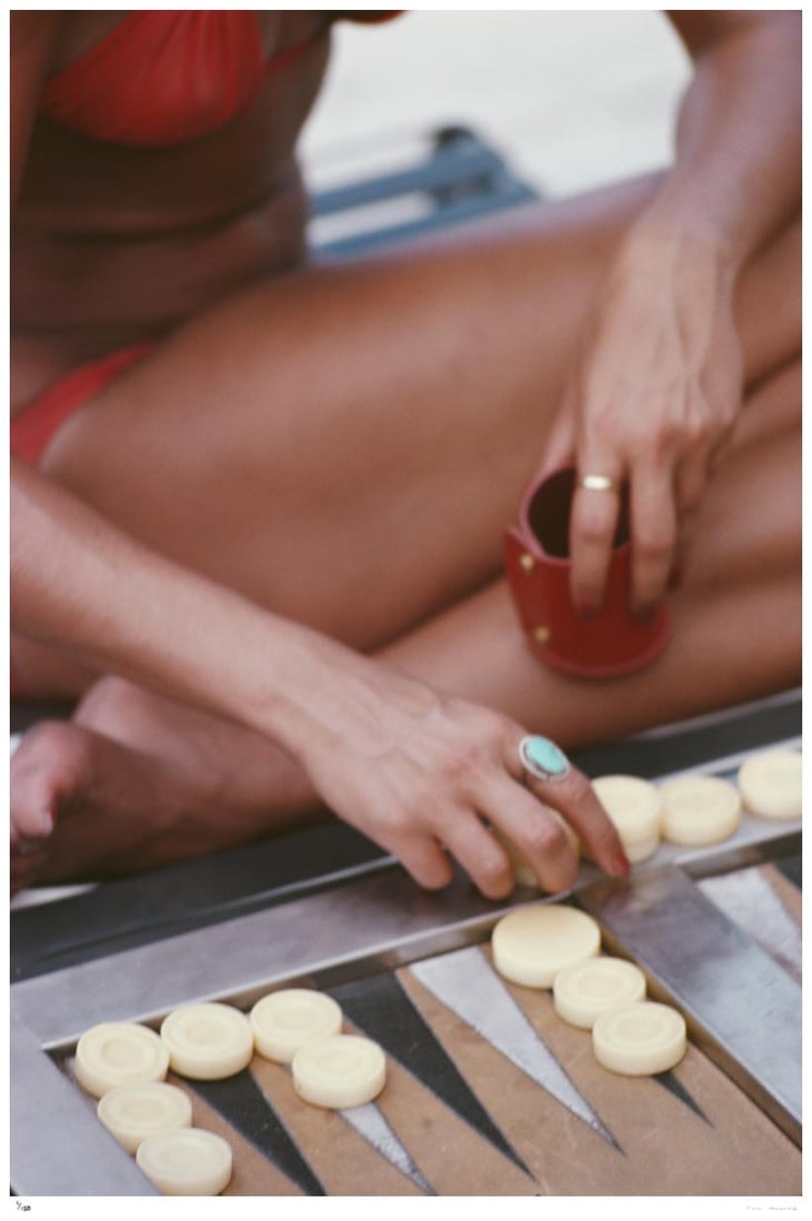 Backgammon In Haiti 1975 - Slim Aarons Estate Stamped: 1975 (printed later): Title: Backgammon In Haiti 1975 - Slim Aarons Estate Stamped: 1975 (printed later) Description: Backgammon In Haiti 1975 - Slim Aarons Estate Stamped Close-up of a woman playing backgammon in Haiti, i