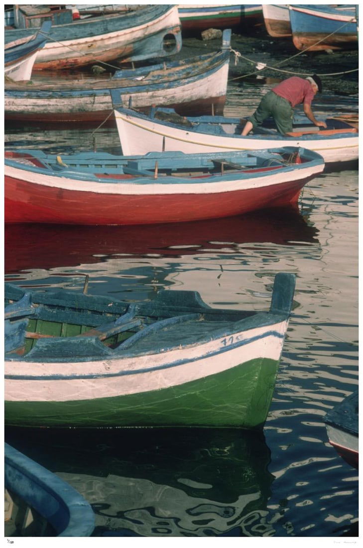 Fishing Boats 1975 - Slim Aarons Estate Stamped: 1975 (printed later): Title: Fishing Boats 1975 - Slim Aarons Estate Stamped: 1975 (printed later) Description: Fishing Boats 1975 - Slim Aarons Estate Stamped A fisherman in his boat at a Sicilian harbour, 1975. 20 x 16"