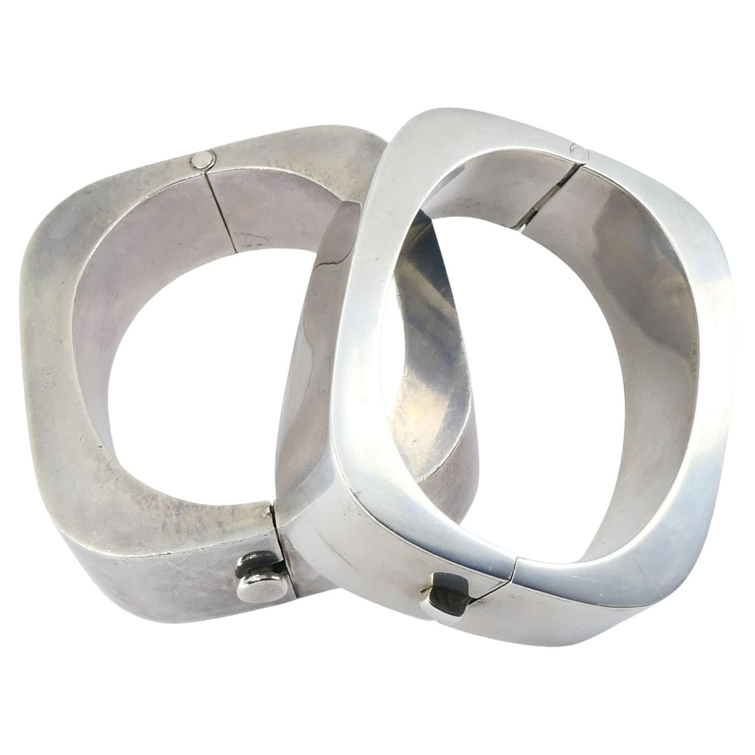Vintage Sterling Silver Mexico Geometric Hinge Bracelet Pair: Title: Vintage Sterling Silver Mexico Geometric Hinge Bracelet Pair Description: A pair of sterling silver hinged bangles from Mexico, crafted with the bold geometric forms characteristic of late-20th