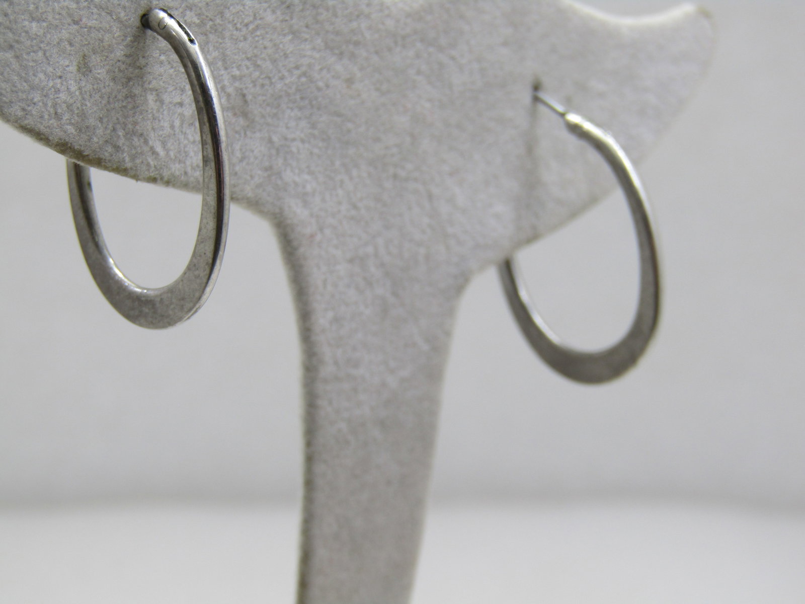 Vintage Silver Tone Hoop Earrings, Pierced, Offset Oval: Vintage Silver Tone Hoop Earrings, Pierced, Offset Oval, 1" long. The earrings are rounded at top at 1.5mm and flatten and widen at the bottom and are 3mm wide. Silver tone metal. Age is appx. 1980's-