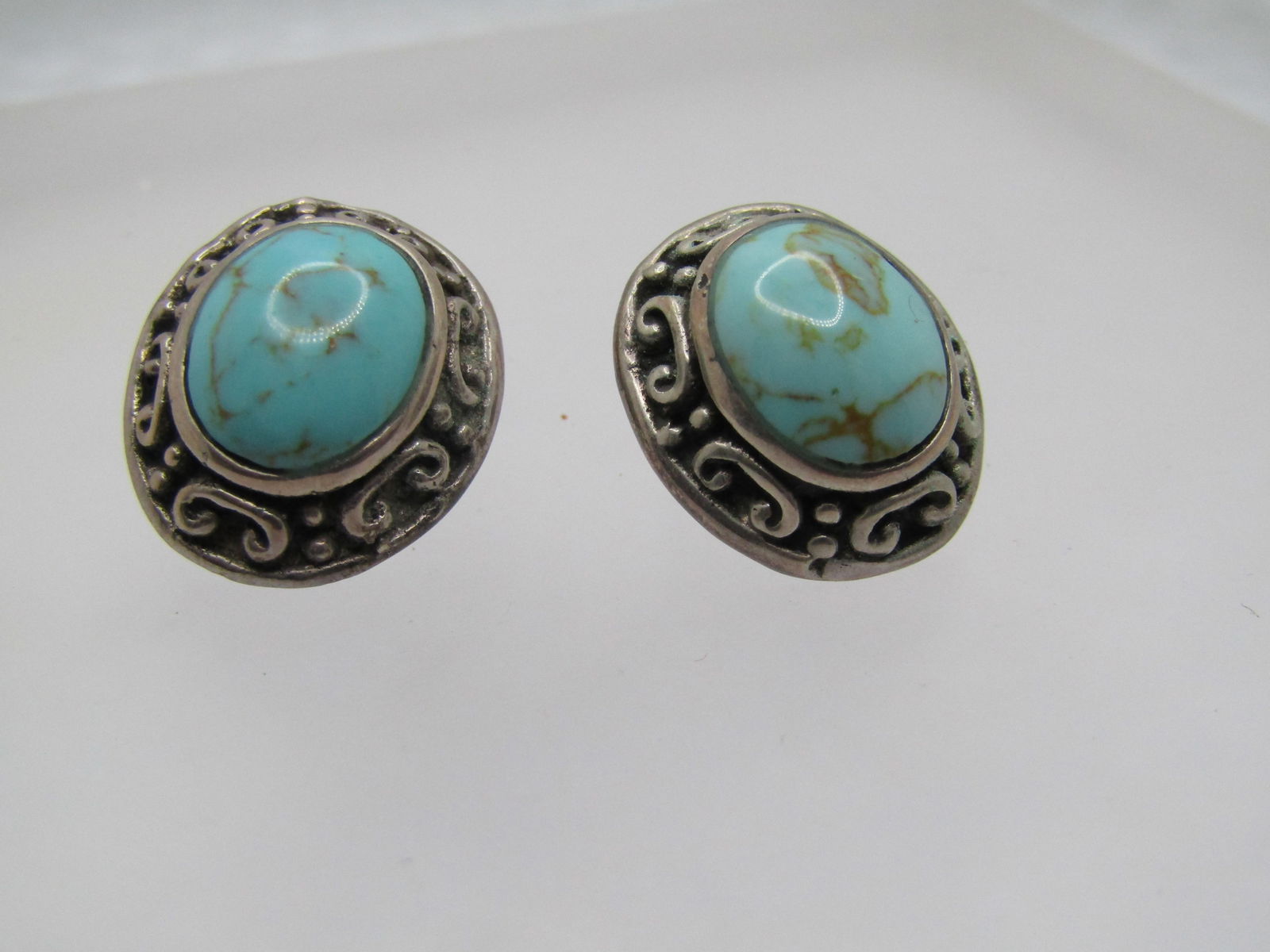 Vintage Sterling Southwestern Faux Turquoise Earrings. 1990's: Vintage Sterling Southwestern Faux Turquoise Earrings. 1990's or after. This also has Boho/Bali appeal. They have a center simulated glass turqoise o al bezel-set stone. Appx. 12mm long and 9mm wide.