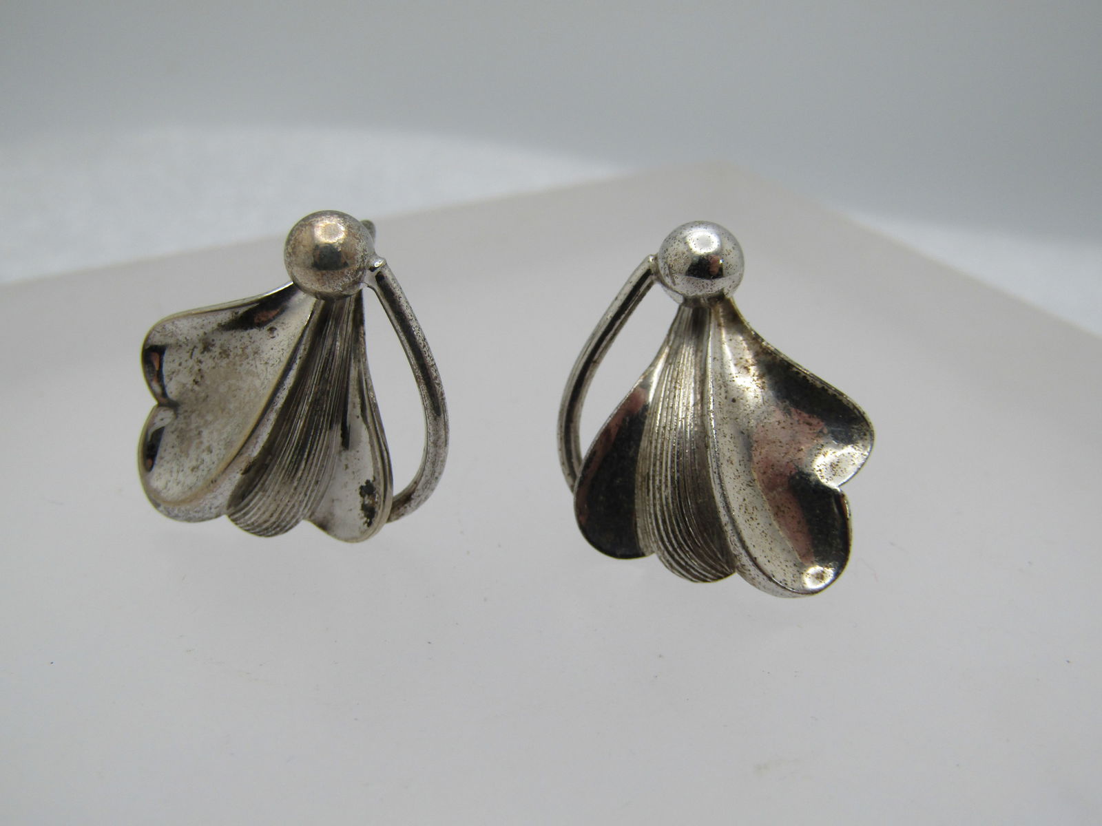 Vintage Sterling Mod Leaf Earrings, 1940's-1950's. Screwback: Vintage Sterling Mod Leaf Earrings, 1940's-1950's. Screwback. The leaves are smooth and shiny and ridged surfaces with a bead at the base and a stem like scroll. They look like two stylized mod hearts