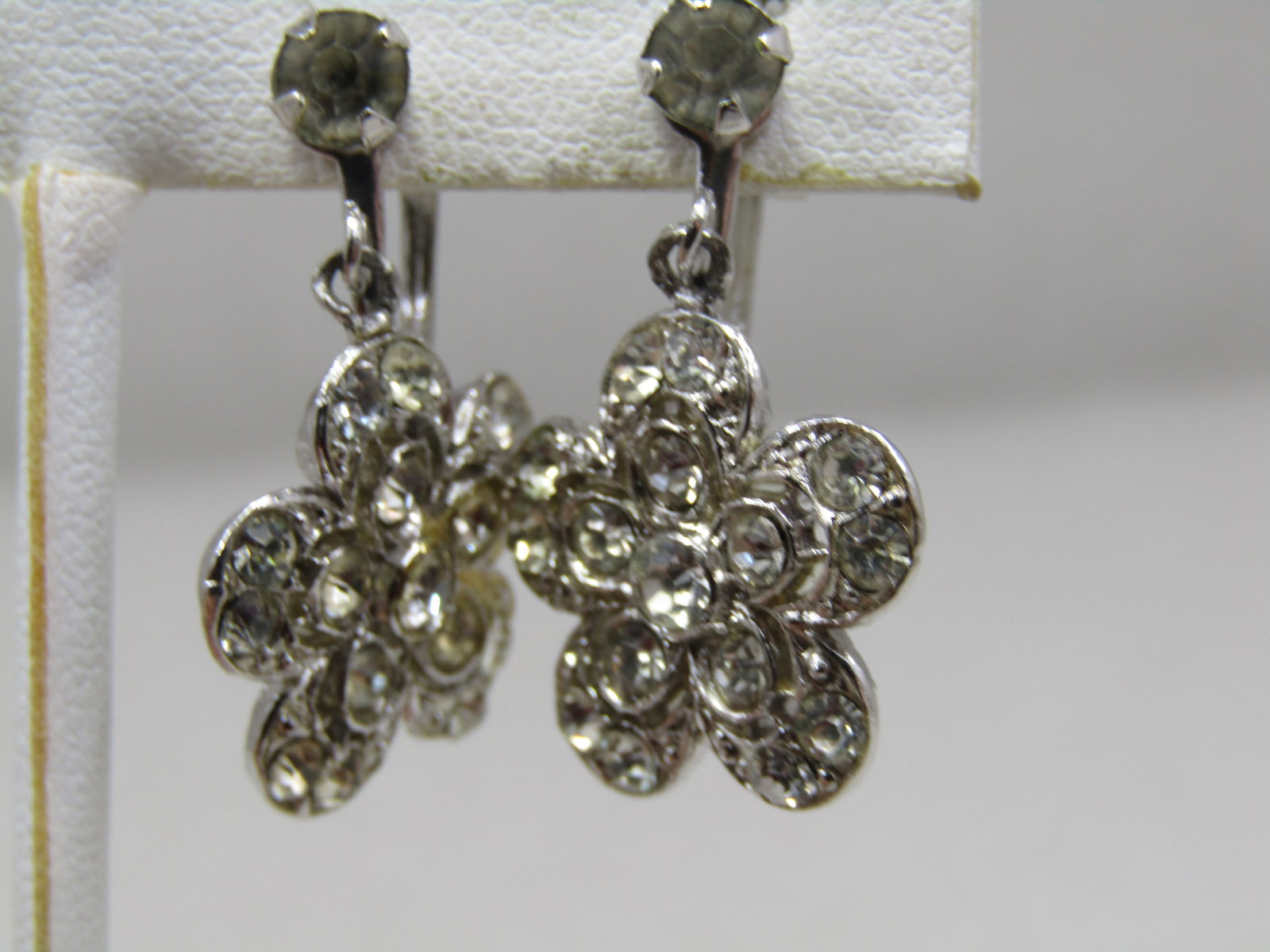 Vintage Rhinestone Floral Stud & Drop Earrings, Screwback: Vintage Rhinestone Floral Stud & Drop Earrings, Screwback. Silver tone earrings with a rhinestone stud and appx. 3/4" blossom dangling from the stud. Total length is appx. 1-1/8". Appx. 1960's-1970's.