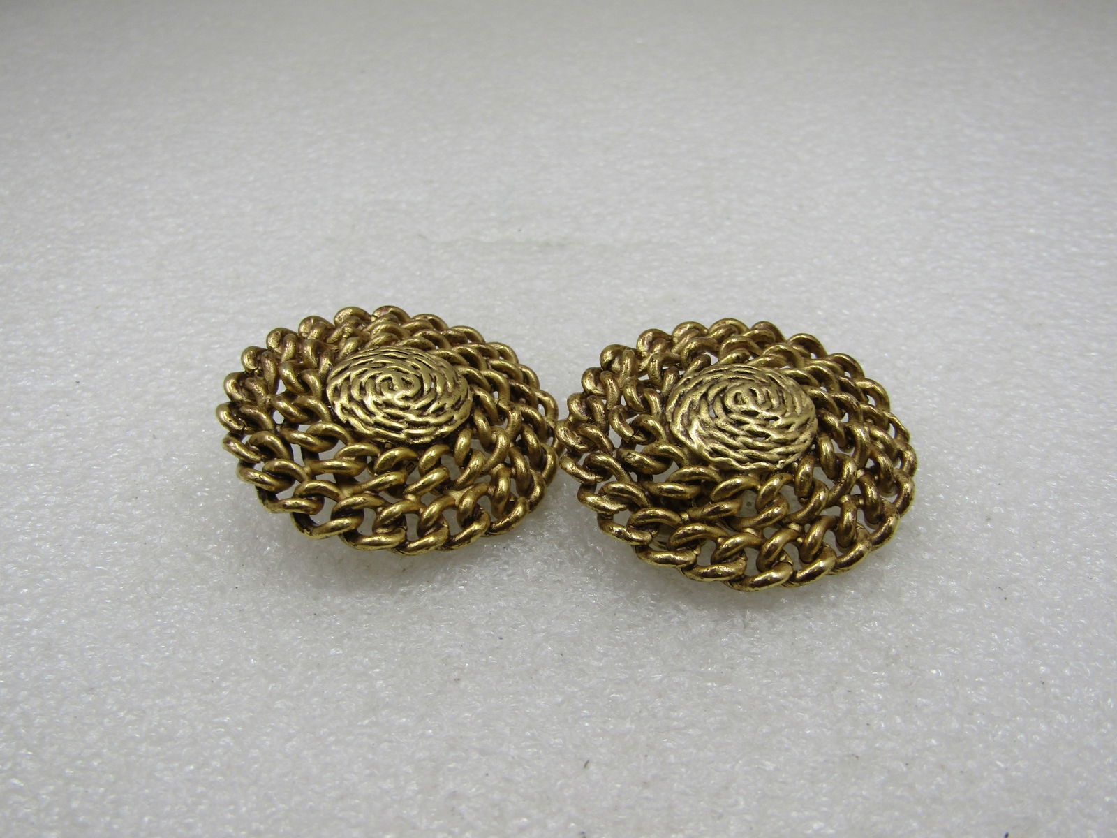 Vintage Curb Link Clip Earrings, 1980's, Gold Tone, 1.5": Vintage Curb Link Clip Earrings, 1980's, Gold Tone, 1.5". They are slight domed with a double row of wrapped open curb link chain on the outer part of the earrings and a slid gold tone center with the