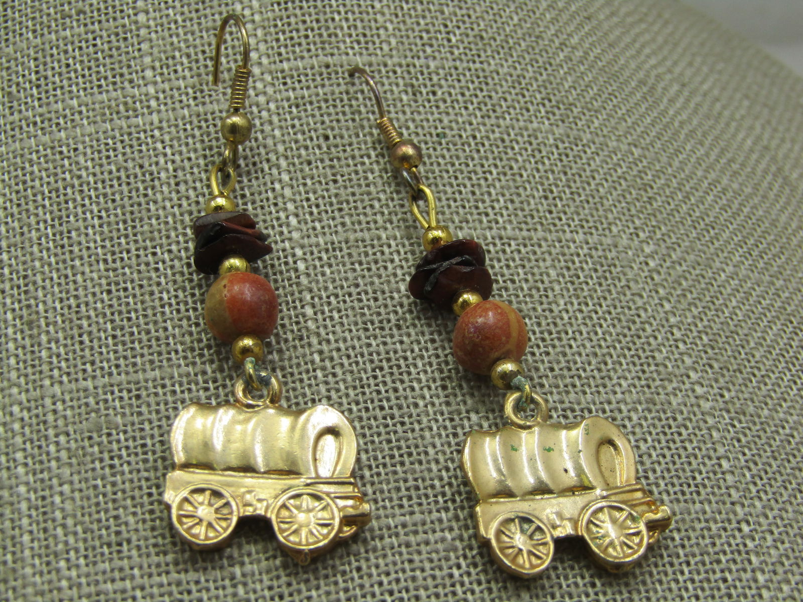 Southwestern Gold Tone Wagon Train Earrings, Pierced, 2.25": Southwestern Gold Tone Wagon Train Earrings, Pierced, 2.25". Tiger's eye flat stone on top with an orange agate bead and gold tone spacer beads. The wagon train is 3/4" tall and wide. Pierce hook post
