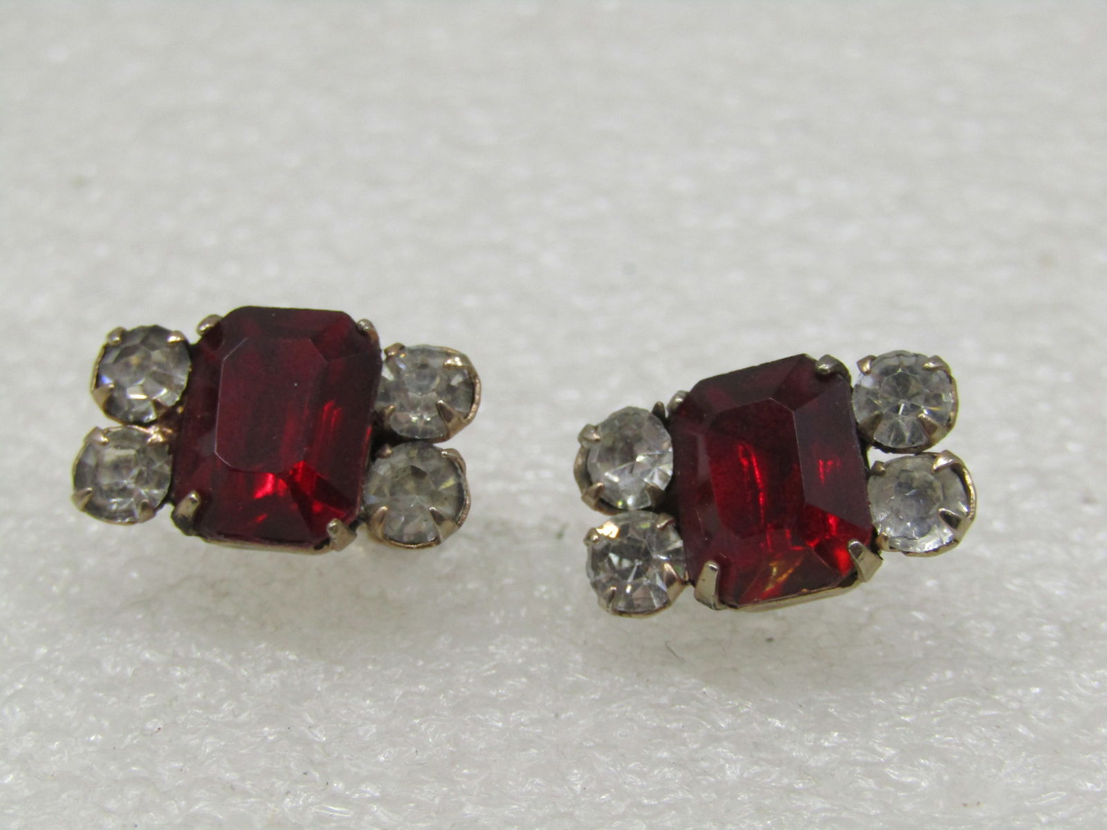Vintage Red & Clear Rhinestone Earrings, Screwback, 1940's-1960's: Vintage Red & Clear Rhinestone Earrings, Screwback, 1940's-1960's. A large prince cut red rhinestone in the center that is appx. 10mm by 7.5mm and foru clear stones, two on each side that are appx. 4m