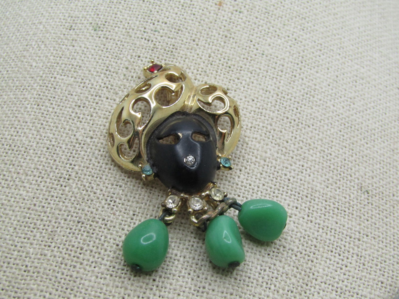 Vintage Blackmoor Woman Brooch Dangles & Rhinestones, Mid-Century, 2.5": Vintage Blackmoor Woman Brooch Dangles & Rhinestones, Mid-Century, 2.5" tall and 1.25" wide. African woman with fancy headdress and red rhinestoneon top, clear rhinestone nose and collar with blue rhi