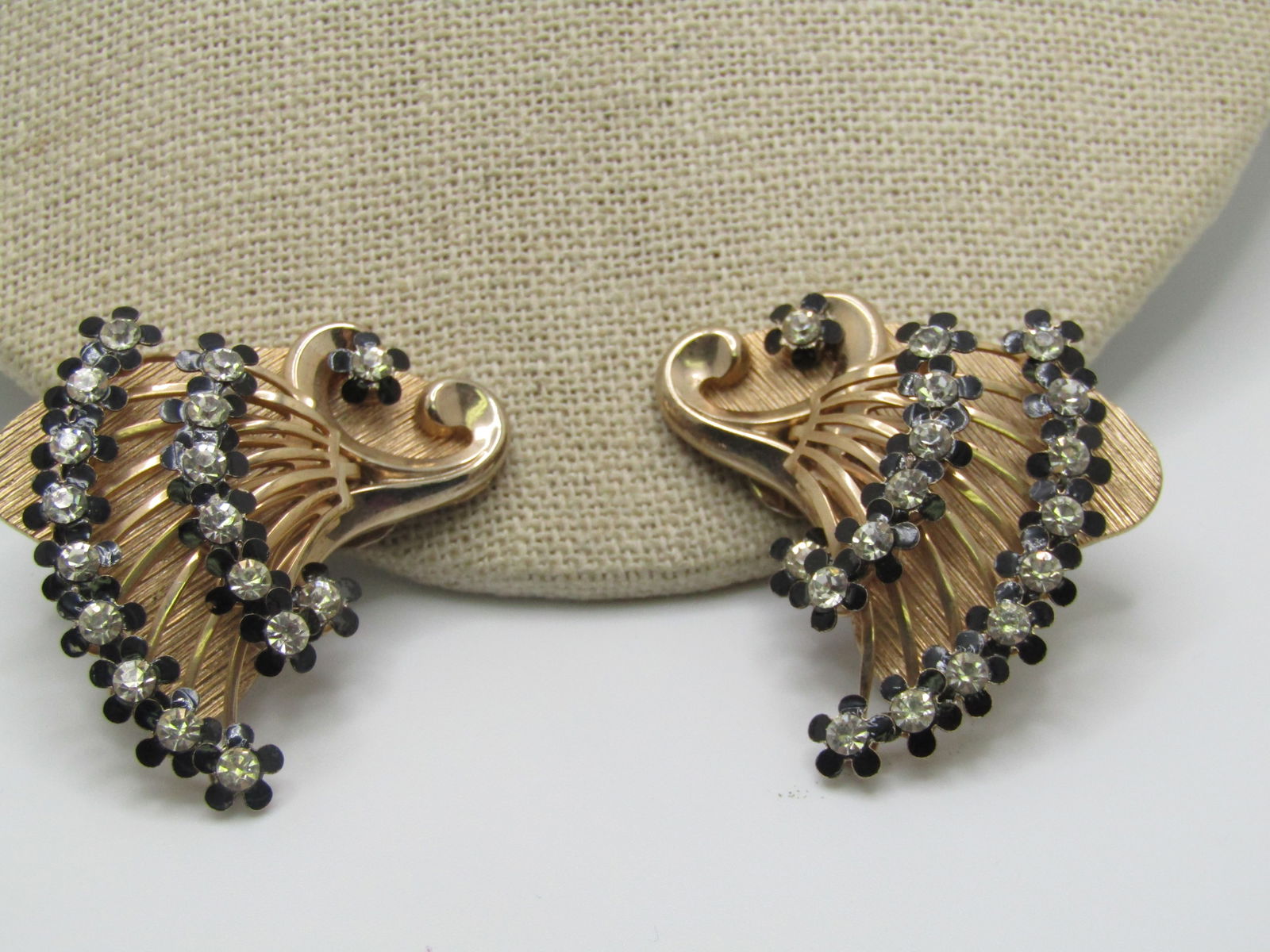 Vintage Blossom Rhinestone Clip Earrings, Art Deco Themed, 1940's: Vintage Blossom Rhinestone Clip Earrings, Art Deco Themed, 1940's. Two rows of black enameled blossom petals and 3m clear rhinestone centers with two random blossoms scattered on the earrings. Coiled