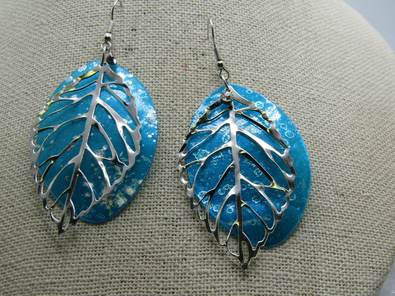 Vintage Aqua Dyed Shell Leaf Earrings, Pierced, Rhinestone Accent: Vintage Aqua Dyed Shell Leaf Earrings, Pierced, Rhinestone Accent. Nearly 3" long with an aqua died shell background piece with splattered silver enameling and an overlay outline of a leaf with vein d