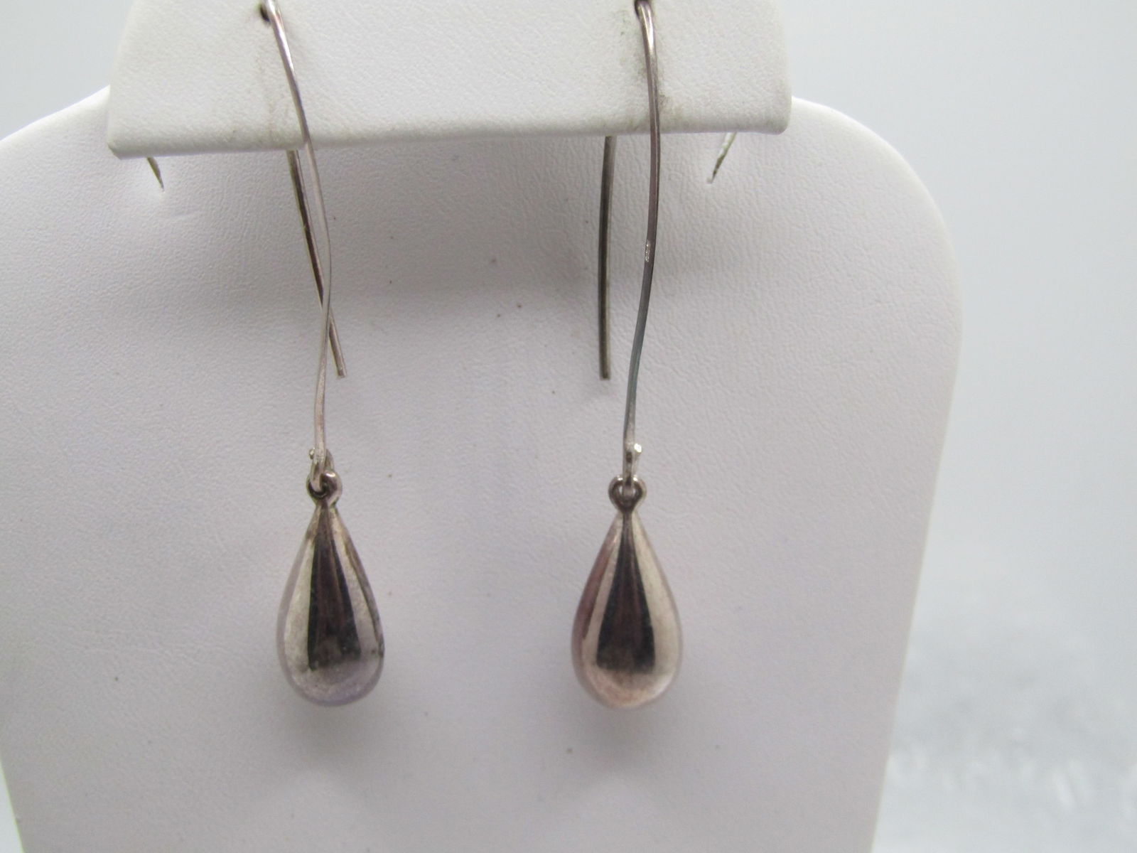 Vintage Sterling Long Dangle Earrings, Hoop-like, 2-3/8": Vintage Sterling Long Dangle Earrings, Hoop-like, 2-3/8". The hook post is an incomplete cat eye shap that is appx. 1.5" long from which a puffy teardrop bead hangs that is appx. 7/8" long and 8mm thi