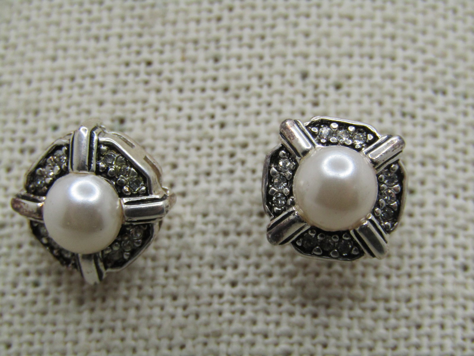 Faux Pearl Rhinestone Stud Earrings, Marked Sterling, 1990's: Faux Pearl Rhinestone Stud Earrings, Marked Sterling, 1990's. Just under 1/2" almost squares with a center 6mm round pearl cabochon and eight clear rhinestones around the pearl. It has a bridged side