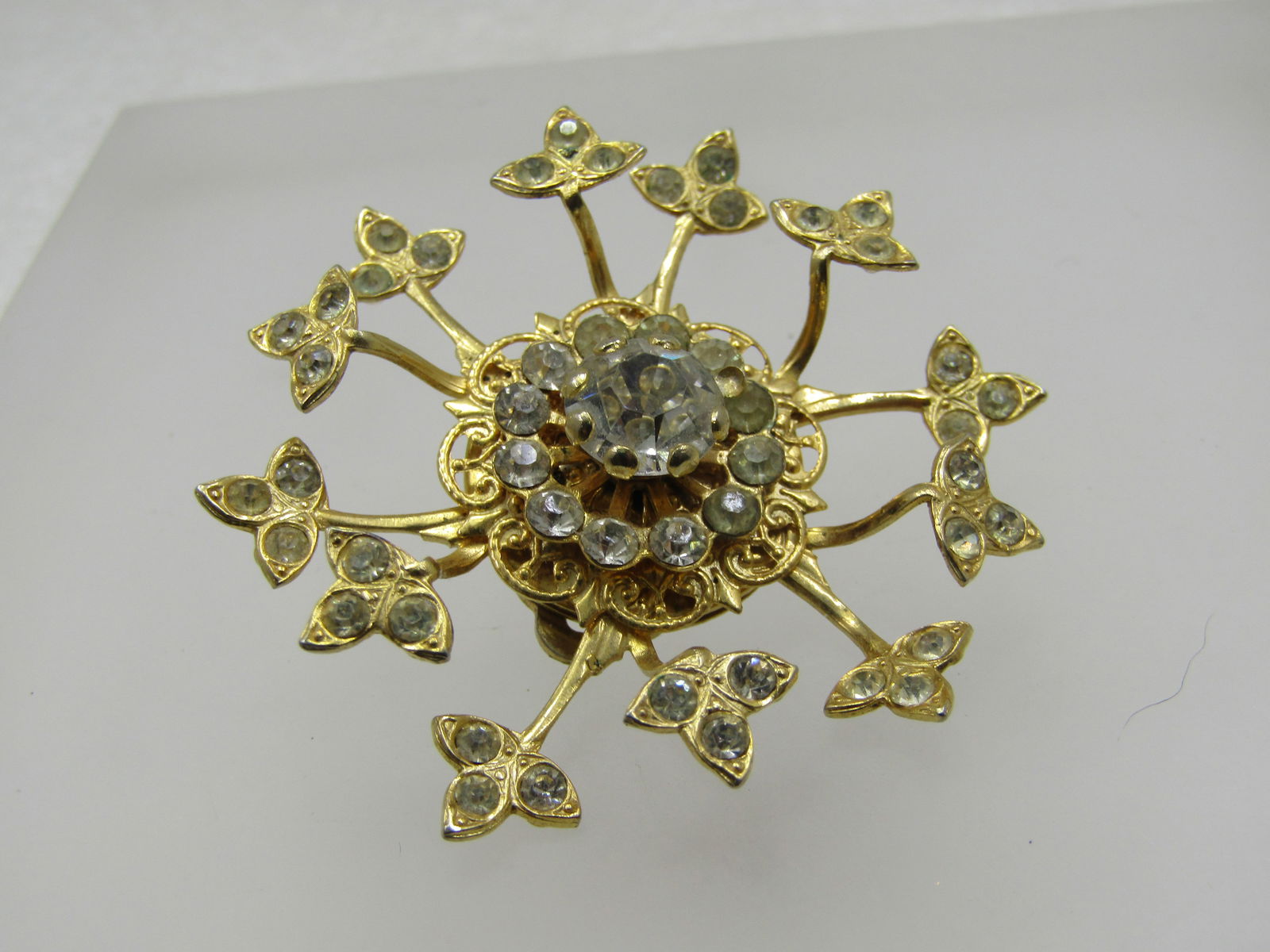 Vintage Large Rhinestone Single Earring, Great as Dress Clip Too: Vintage Large Rhinestone Single Earring, Great as Dress Clip Too. This earring is 2" wide with a tiered center, filigree base and a row of 2.5mm rhinestones with an 8mm center rhinestone. The outher e