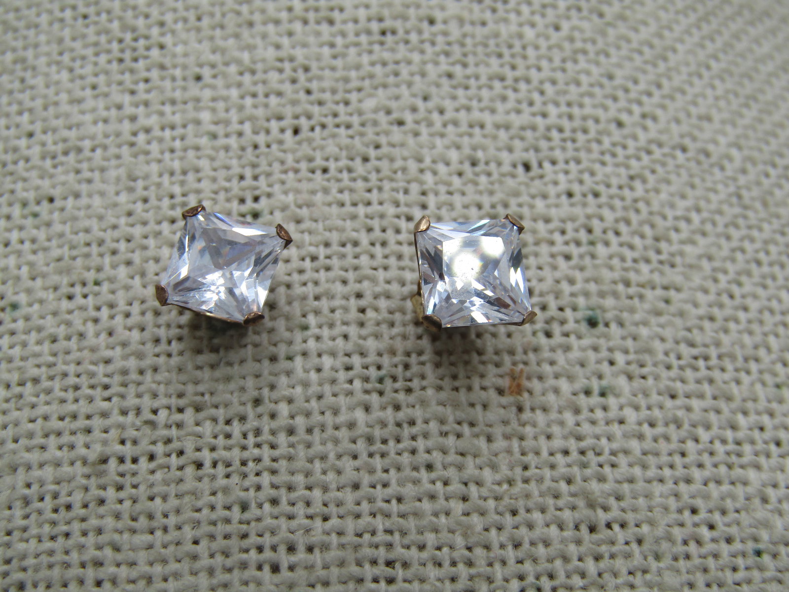 10kt CZ Square Earrings, 6mm, 10kt Posts, Unisex Signed: 10kt CZ Square Earrings, 6mm, 10kt Posts, Unisex. Signed JCM. The posts are marked 10kt and tested and the clutches are marked 1/20 14kt G.F. clutches. Total weight of the earrings is appx. .96 gr. Co