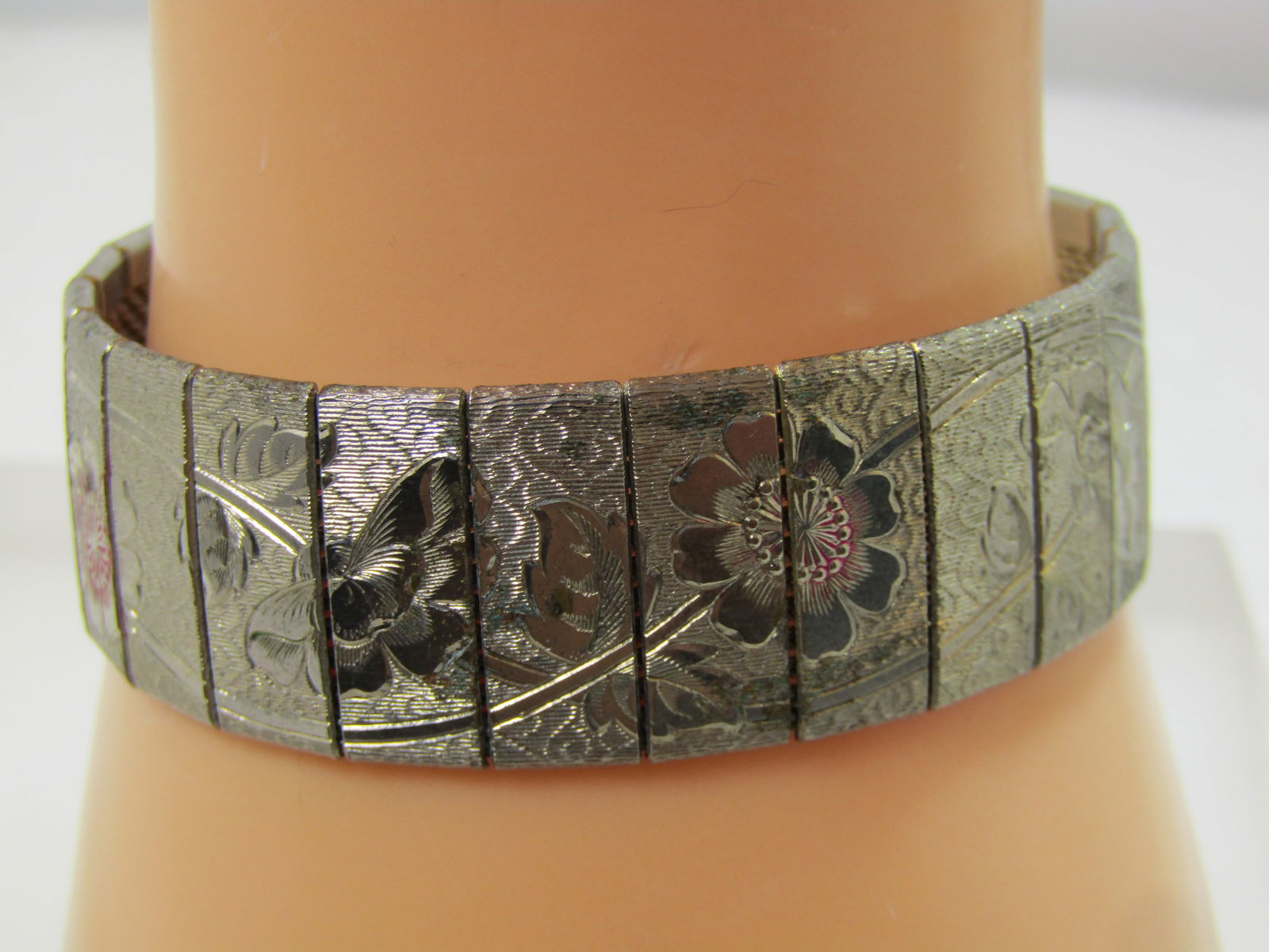 Vintage Articulated Wide Floral Bracelet, 1960's: Vintage Articulated Wide Floral Bracelet, 1960's. This is appx. 3/4" wide and 7" with lkght enameled accents in pink to pale red on four of the flowers. It is silver tone with a mesh back and each of
