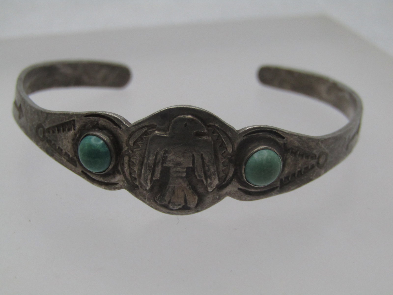 Vintage Sterling Thunderbird Turquoise Cuff Bracelet, Youth, 5.5", 1950's-1960's: Vintage Sterling Thunderbird Turquoise Cuff Bracelet, Youth, 5.5", 1950's-1960's. I thas two round bezel-set turquoise stones that are appx. 4.5mm round with a thunderbird raised image in the center