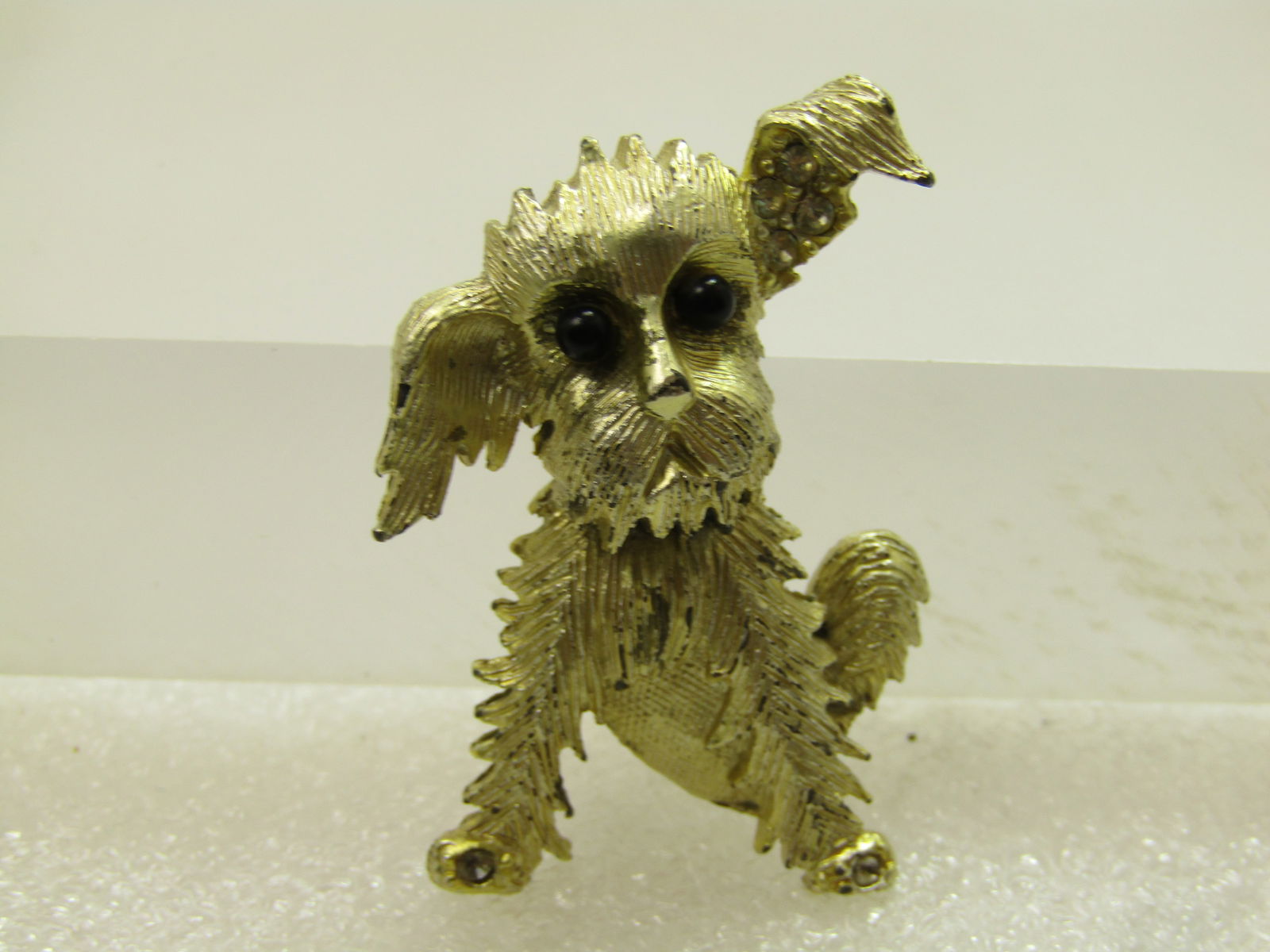 Vintage Dog/Terrier Brooch,Rhinestone Accents, Textured, 1960's-1970's.: Vintage Dog/Terrier Brooch,Rhinestone Accents, Textured, 1960's-1970's. Gold tone with mixed textures to give the dog a great design. Black beded eyes and clear rhinestones on the inside of one ear. I