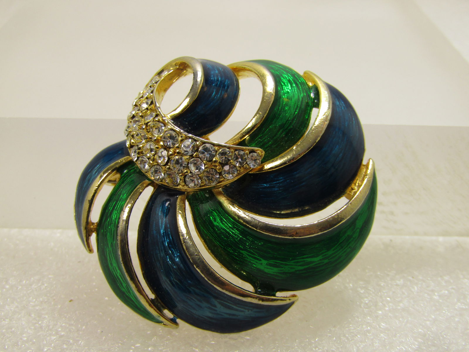 Vintage Enameled Blue/Green Spiral Brooch, Rhinestones, 1980's: Vintage Enameled Blue/Green Spiral Brooch, Rhinestones, 1980's. This has alternating rich enameled blue and green spiral bands that form a blossom like design with a curved triple rhinestone row comin