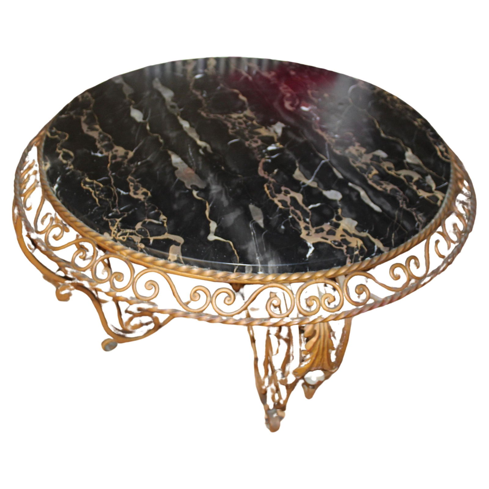 Mid Century/Art Deco Coffee Table after Gilbert Poillerat: An Art Deco designed wrought Iron forged round Coffee Table by the Designer (Gilbert Poillerat ) with a gold painted finish and an Italian (black n Gold ) marble top . Outside diameter of the table is