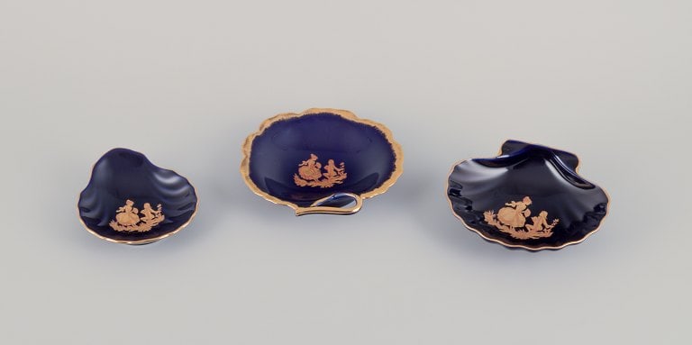 Limoges, France. Three bowls in porcelain decorated with 22-karat gold leaf and beautiful royal blue: Title: Limoges, France. Three bowls in porcelain decorated with 22-karat gold leaf and beautiful royal blue glaze. Scène galante. Description: Limoges, France. Three bowls in porcelain decorated