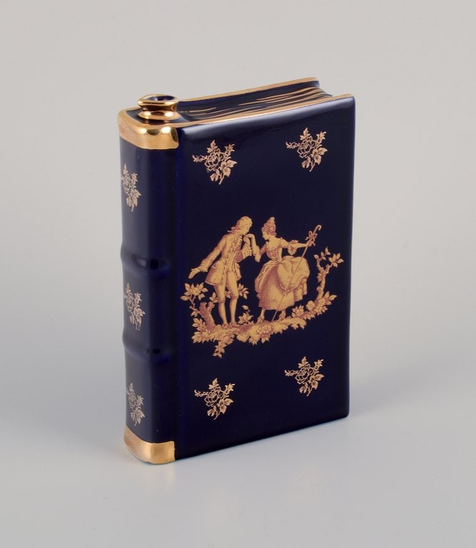 Limoges, France. Porcelain "hip flask" shaped like a book decorated with 22-karat gold leaf and: Title: Limoges, France. Porcelain "hip flask" shaped like a book decorated with 22-karat gold leaf and beautiful royal blue glaze. Scène galante. Description: Limoges, France. Porcelain "hip
