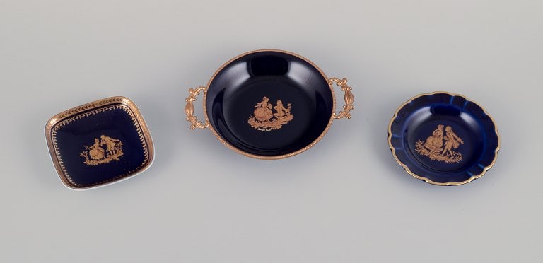 Limoges, France. Three small porcelain bowls decorated with 22-karat gold leaf and beautiful royal: Title: Limoges, France. Three small porcelain bowls decorated with 22-karat gold leaf and beautiful royal blue glaze. Scène galante. Description: Limoges, France. Three small porcelain bowls