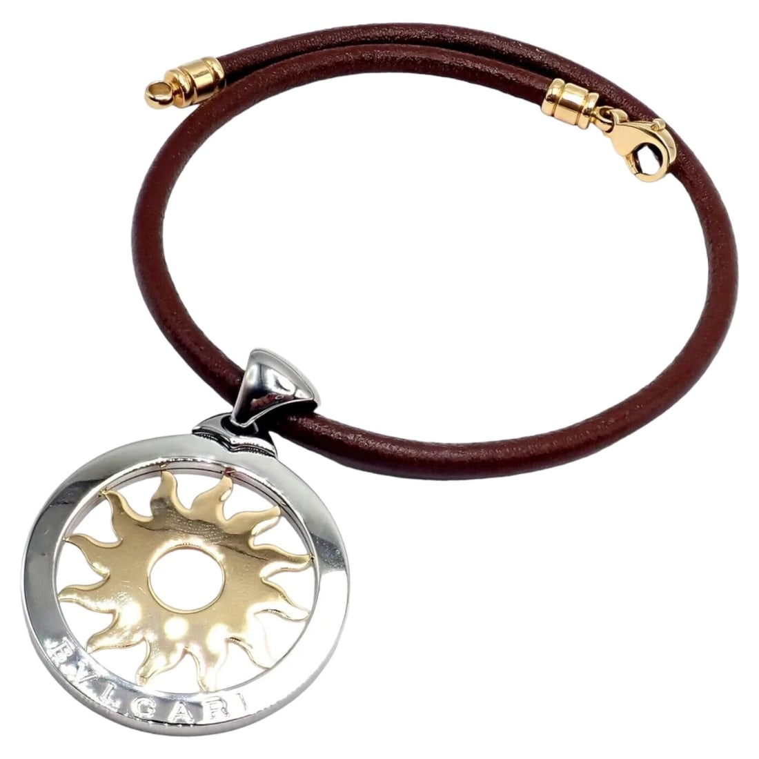 Bulgari Tondo Sun 18k Gold Steel Extra Large Pendant Brown Leather Necklace: Bulgari Tondo Sun 18k Gold Steel Extra Large Pendant Brown Leather Necklace About This Piece: The Bulgari Tondo Sun pendant features an 18k gold and steel design, showcasing an intricate sun motif. Th