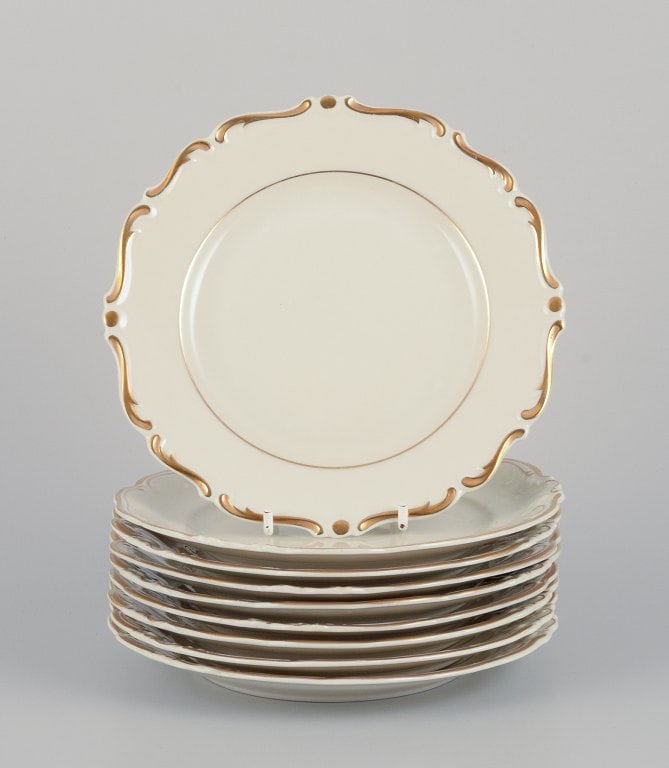 KP, Karlskrona, Sweden. A set of nine cream-colored porcelain plates with gold decoration. (1 of 5)