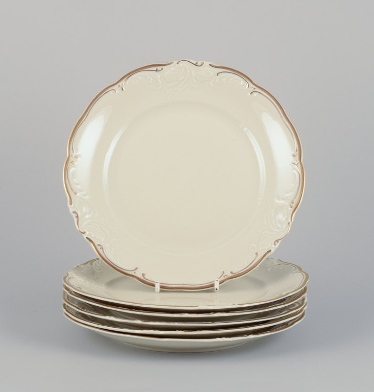 KPM, Poland. A set of six porcelain lunch plates. Cream-colored with gold rim decoration. (1 of 5)
