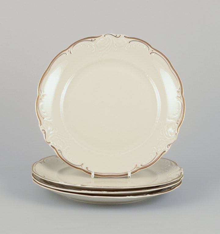 KPM, Poland. A set of four porcelain lunch plates. Cream-colored with gold rim decoration. (1 of 5)