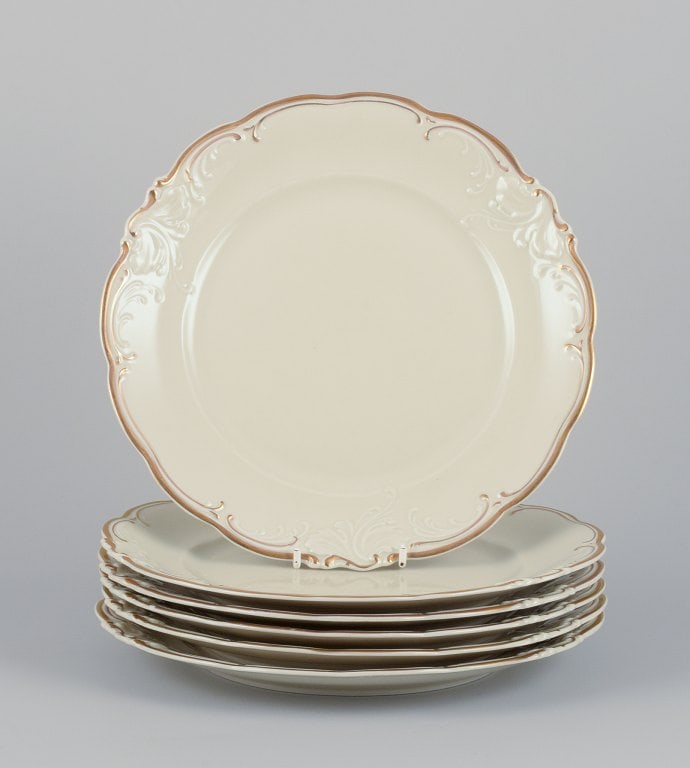 KPM, Poland. A set of six dinner plates in cream-colored porcelain. Decorated with a gold rim. (1 of 6)