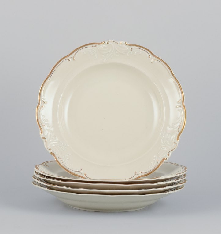 KPM, Poland. A set of five large deep porcelain plates in cream color. Gold-rim decoration. (1 of 5)