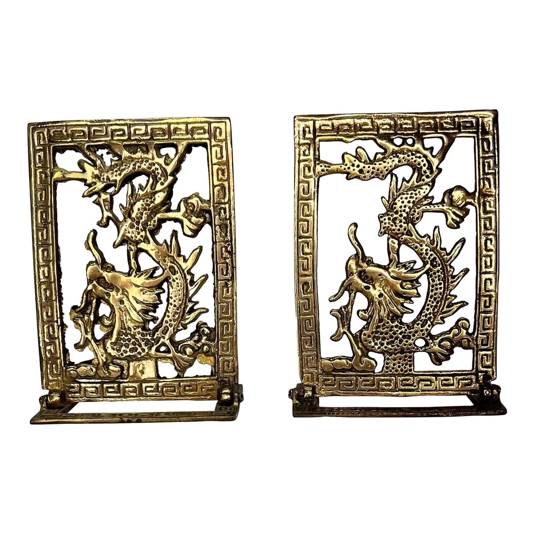 Vintage Dragon Design Brass Chinoiserie Bookends With Greek Key Border: Vintage pierced dragon design brass bookends framed with Greek key border. Measure 3.75" w x 3" d x 5.5" h. Extends under book 1.5". Condition: Alterations: Original Condition Unaltered