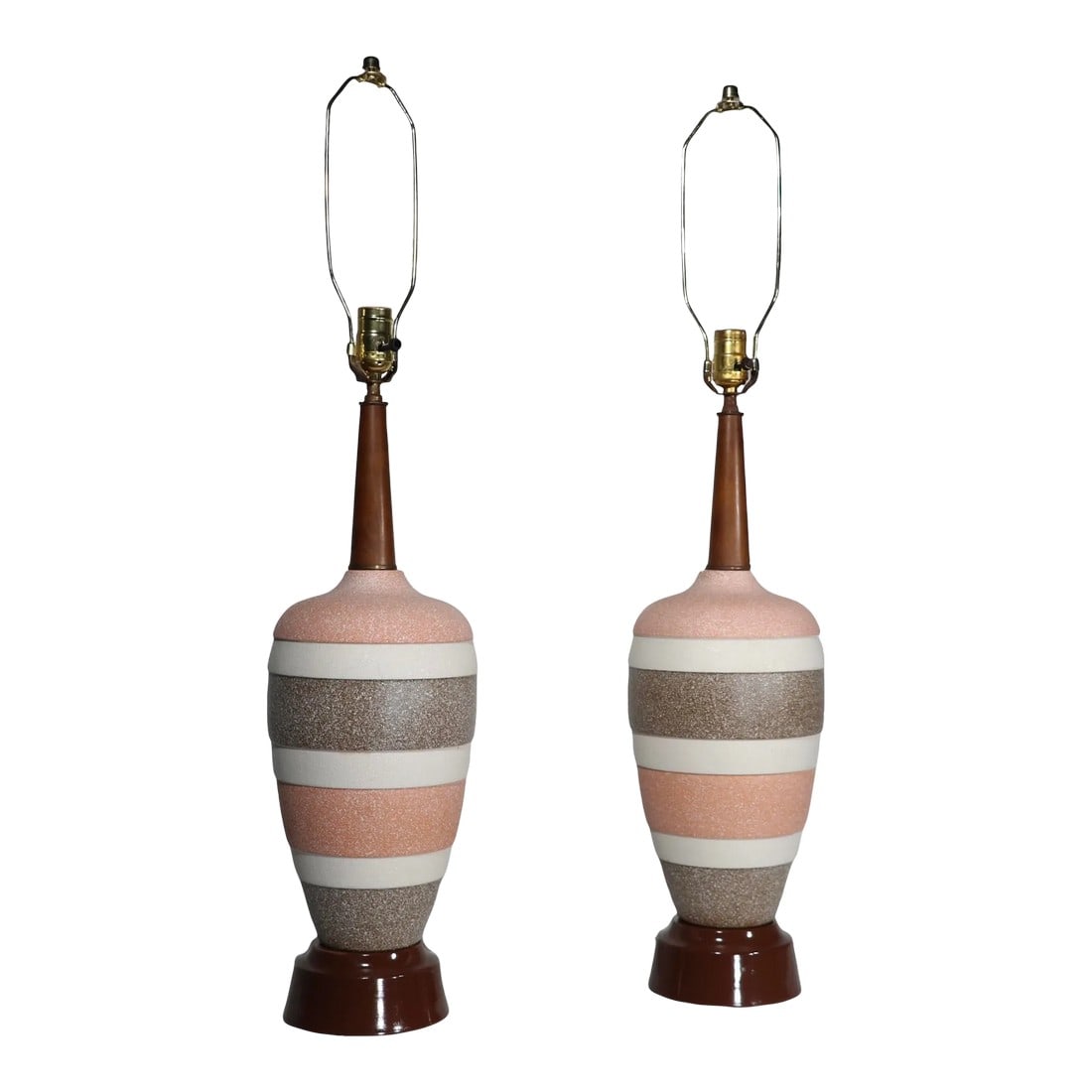 Pr. Mid Century Ceramic Table Lamps: Pr. ceramic Mid Century table lamps having textured surfaces with brown, tan and off white banded bodies with tapered wood tops, on metal plinth bases. Both lamps are in very good, clean, working and