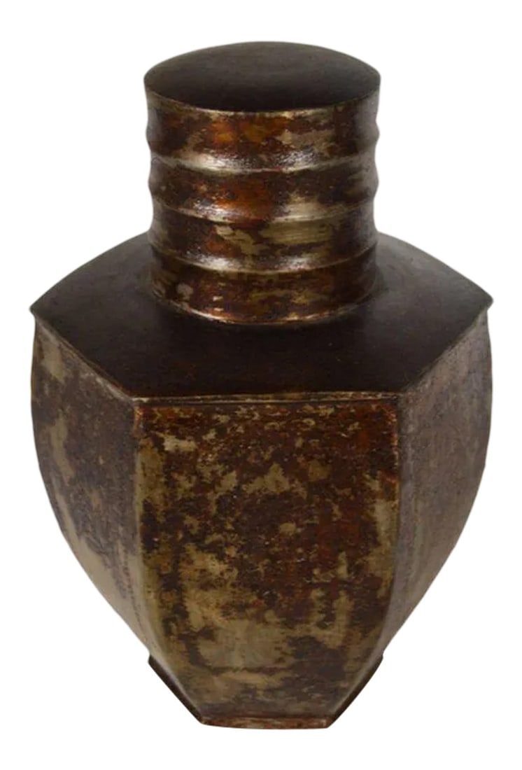 Vintage Indian Hand-Hammered Distressed Tin Storage Canister, Early 20th Century: An early 20th century storage canister hand-hammered on distressed tin from India. This canister adopts a six-sided shape with a round belly finishing on a narrow base. The cylindrical neck is hidden