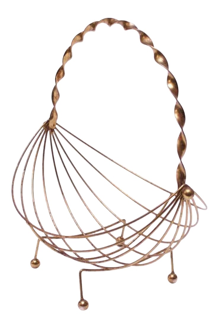 Mid-Century Modern Brass Decorative Basket: Shapely circa 1950s American basket composed of wire brass rods, a braided handle and ball feet. Suitable for holding fruit, eggs, small accessories, etc. There is minor wear / tarnish to the brass,
