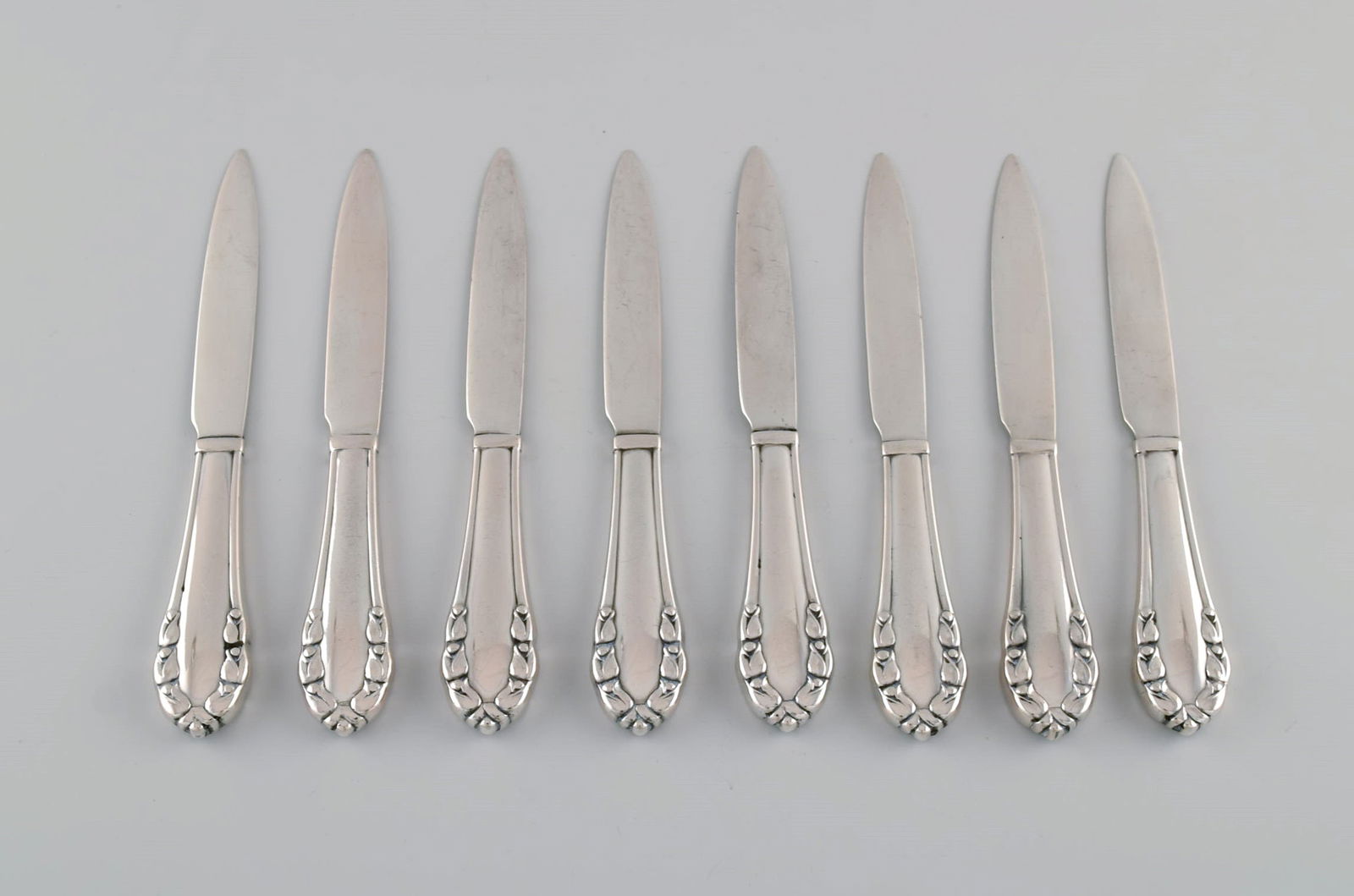 Eight early Georg Jensen Lily of the valley fruit / butter knives in solid silver (830). Dated: Title:Eight early Georg Jensen Lily of the valley fruit / butter knives in solid silver (830). Dated 1915-1930. Description:Eight early Georg Jensen Lily of the valley fruit / butter knives in solid s