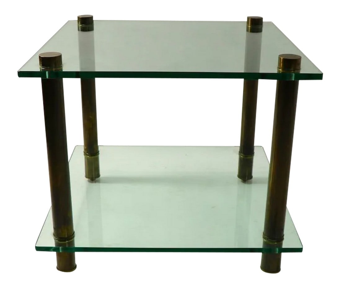 1960s Square Two Tier Glass and Brass End Table: Modernist two tier glass and brass side, or end table having thick plate glass surfaces with tubular brass legs. Simple less is more design concept, very fine materials and top shelf craftsmanship.; T