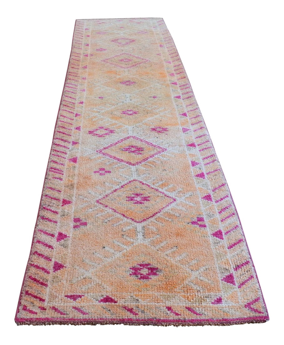 1960s Vintage Kurdish Runner: Offered is a matchless Kurdish runner rug, made in Anatolia approximately 50-60 years ago. The beautiful wool on cotton low pile features multicolored rich floral patterns on a wavy soft orange 