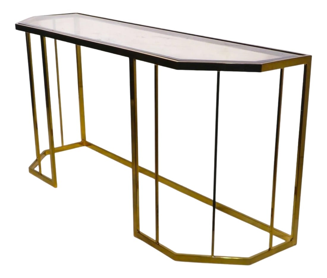 Hollywood Regency Style Brass and Glass Console C. 1970/80's: Chic brass plated and beveled and tinted glass console table executed in the Hollywood Regency style, circa 1970/80's. The console features, a six sided base constructed of brass plated metal, which