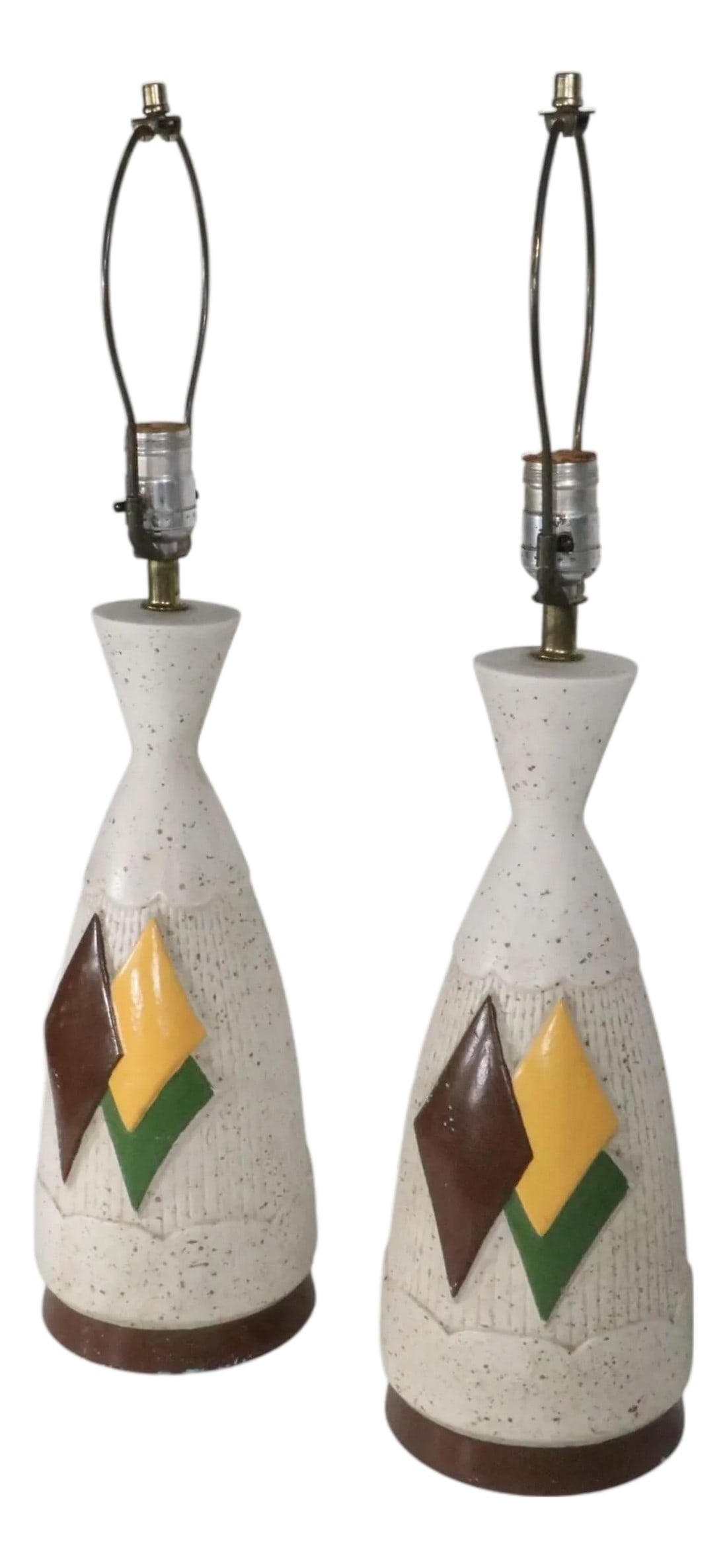 Pair of Mid Century Ceramic Table Lamps: Pair of diminutive ceramic ( plaster ) mid century table lamps, having a layered diamond decorative motif, in brown, yellow, and green, on an off white with gold spatter ground. Both lamps are in good